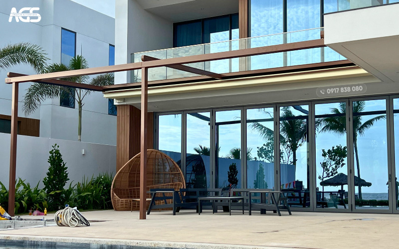 Khu vực thư giãn bên hồ bơi tại villa Sanctuary Hồ Tràm hoàn hảo với mái bạt xếp AGS