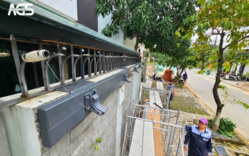Mái che ô tô được lắp chắc chắn lên tường trước nhà.