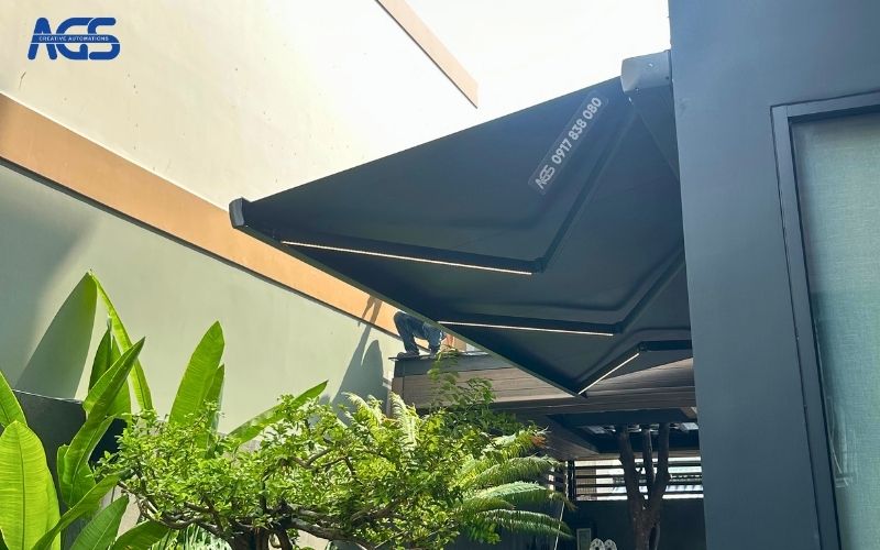 Mái hiên có khung bạt xám hòa vào kiến trúc tổng thể.